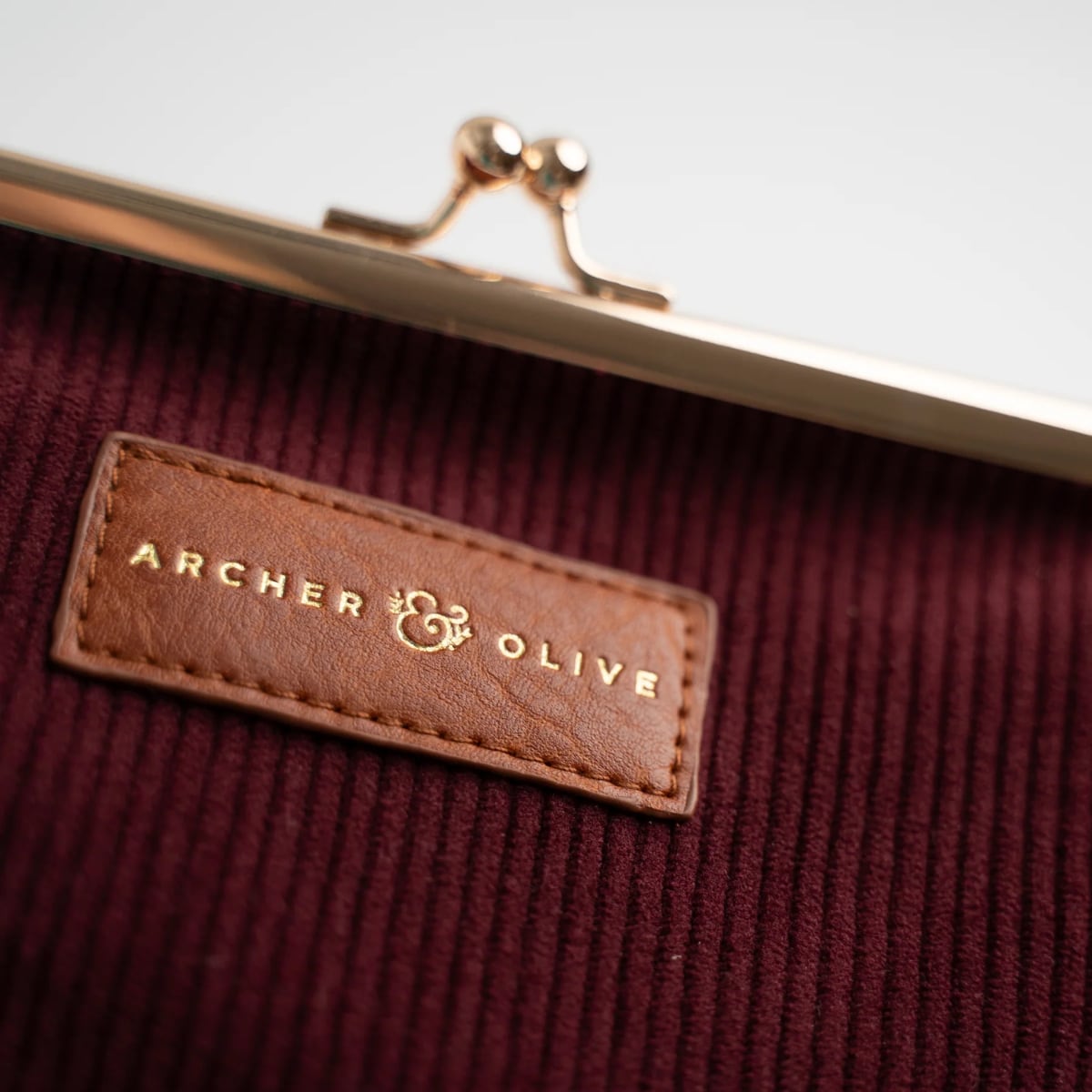 Archer & Olive Quiet Corners Kiss-Lock Pouch - Maroon - Detailfoto van het logo