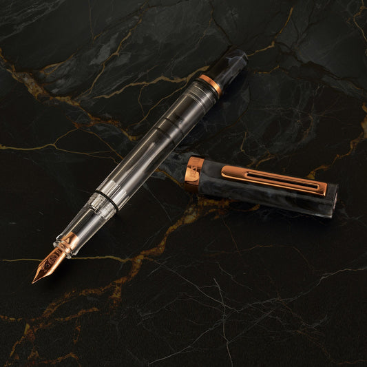 TWSBI Eco Fountain Pen Black Marble with Bronze - Vulpen zonder dop op een marmeren achtergrond
