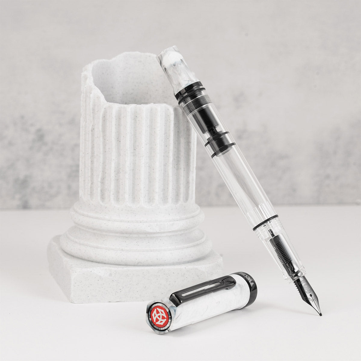 TWSBI Eco Fountain Pen Carrara with Onyx - Staand tegen een marmeren pilaar met de dop ernaast
